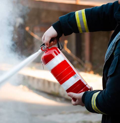 A man conducts exercises with a fire extinguisher. Fire extinguishing concept. Fire emergency incident